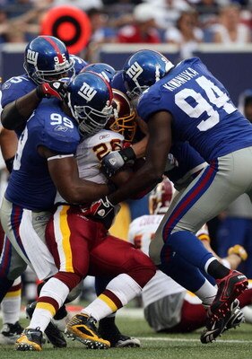 EAST RUTHERFORD, NJ - SEPTEMBER 13:  Clinton Portis #26 of the Washington Redskins is stopped by the defense of the New York Giants on September 13, 2009 at Giants Stadium in East Rutherford, New Jersey.  (Photo by Jim McIsaac/Getty Images)