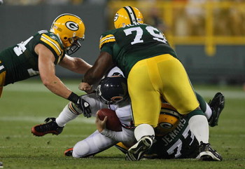 GREEN BAY, WI - SEPTEMBER 13: Ryan Pickett #79, Cullen Jenkins #77 and Aaron Kampman #74 of the Green Bay Packers tackle Jay Cutler #6 of the Chicago Bears on September 13, 2009 at Lambeau Field in Green Bay, Wisconsin. The Packers defeated the Bears 21-1