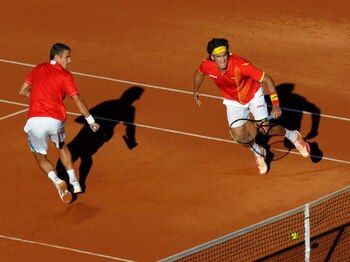 BENIDORM, SPAIN - MARCH 07:  Feliciano Lopez (R) of Spain hits the ball against the net flanked by his doubles partner Tommy Robredo during their doubles match against Nenad Zimonjic and Viktor Troicki of Serbia on day one of the Davis Cup World Group fir